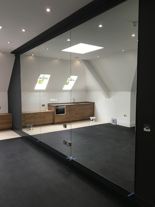 Frameless glass partition in loft conversion by West Ealing glaziers