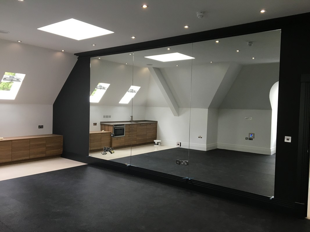 Frameless glass wall dividing loft conversion in West Ealing